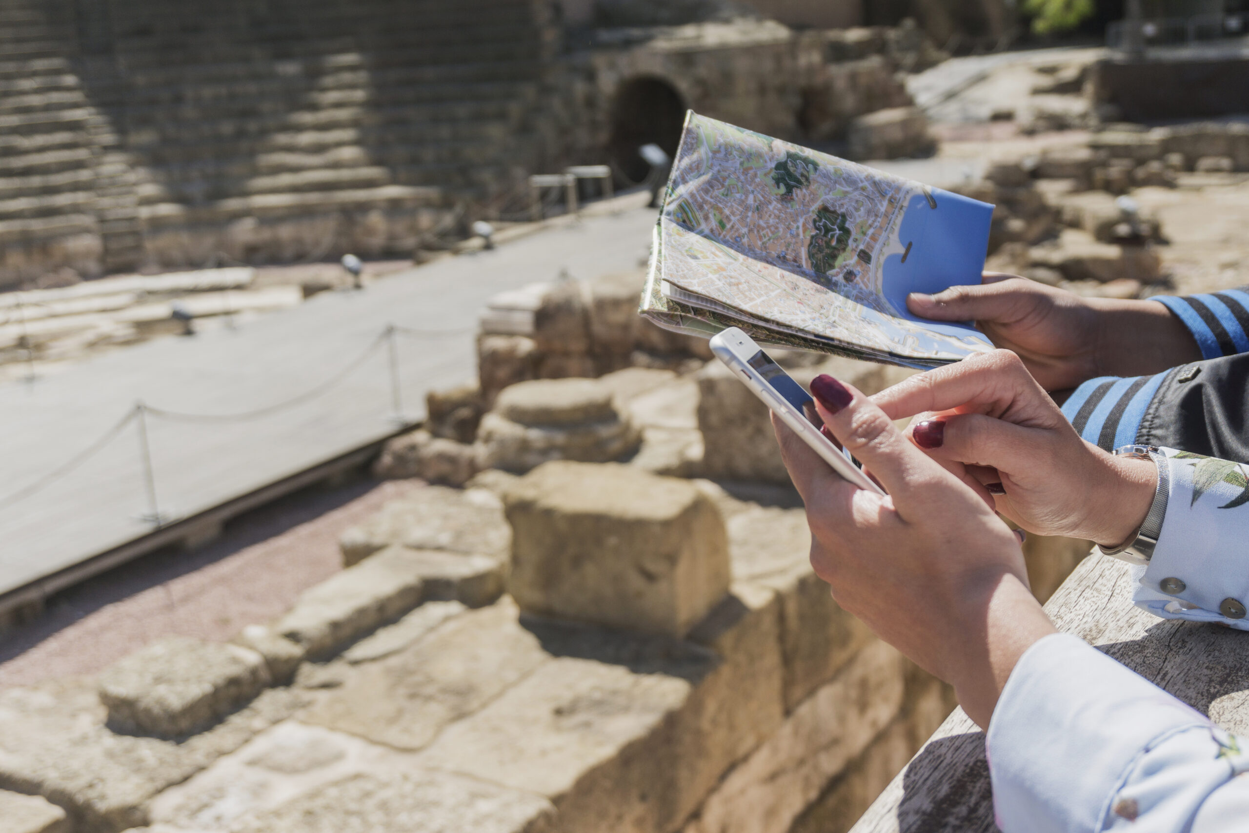 Duas pessoas turistando com um mapa e um celular na mão